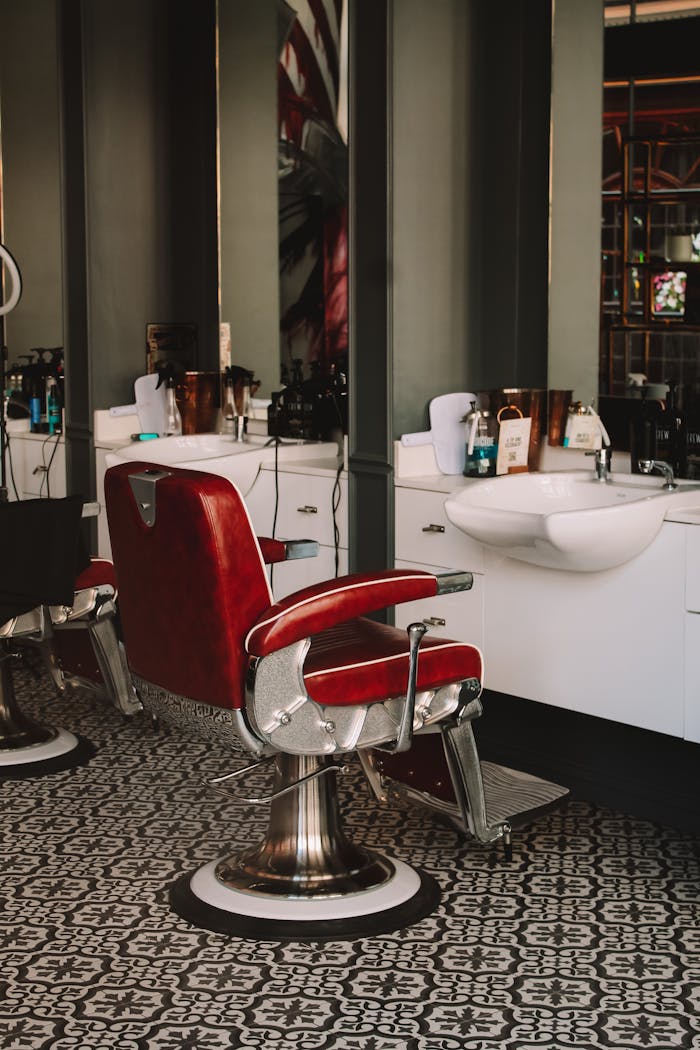 Stylish barbershop interior featuring iconic red leather chairs and modern decor.